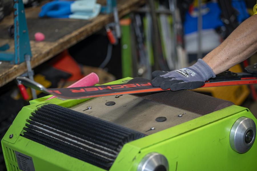 Ski-Service: Ein Ski wird an einer Werkstattmaschine bearbeitet