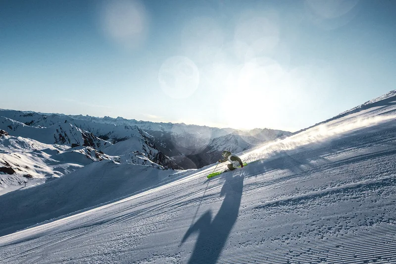 Skifahrer mit Helm auf einer verschneiten Bergpiste